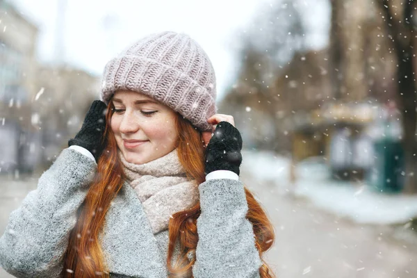 敏感な赤い髪の女性は雪の中 街を歩くコートを着ています テキストのスペース — ストック写真