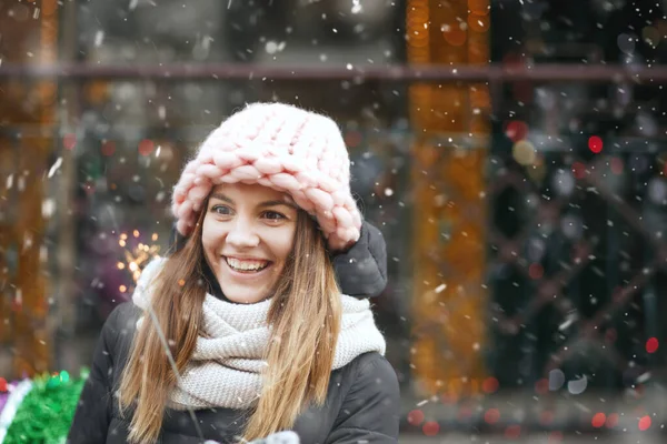 Caddede parlak ışıklarla oynayan neşeli genç bir kadın. Boş boşluk