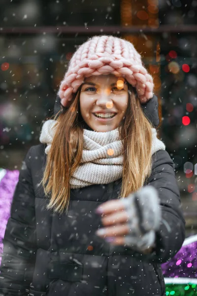 Sokakta ışıldayan ışıklarla oynayan sevimli genç bir kadın. Boş boşluk