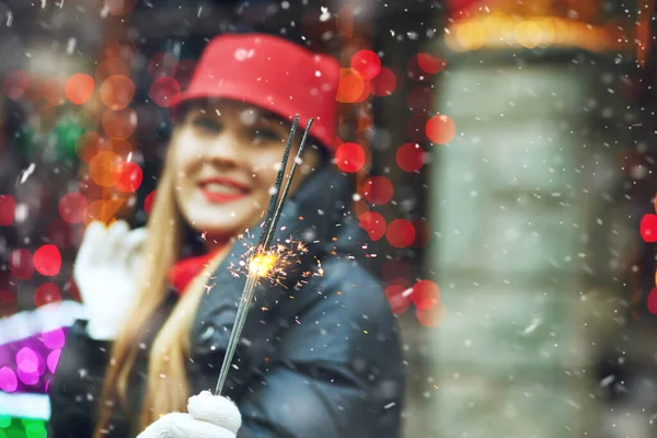 迷人的金发女人在节假日的集市上戴着红色的帽子 上面点缀着灯笼 案文的篇幅 — 图库照片