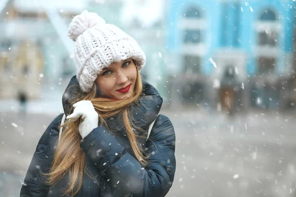 Kar Yağışı Sırasında Şehirde Yürüyen Örgü Şapkalı Mutlu Sarışın Kadın — Stok fotoğraf