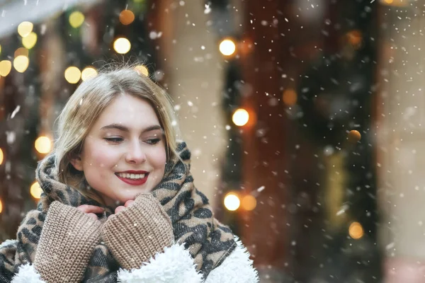 美丽的年轻女子穿着温暖的围巾 在降雪时步行在城市里 空旷的空间 — 图库照片