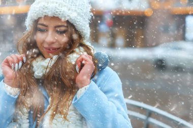 Havalı sarışın kadın, kar yağarken Noel sokak fuarında eğleniyor. Boş boşluk