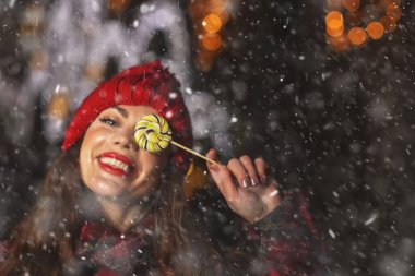 Noel pazarında şeker tutan hoş bir genç bayan. Boş boşluk
