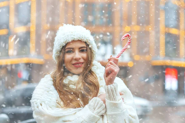 Zadowolona Blondynka Trzymająca Cukierki Świątecznych Targach Zimowych Podczas Opadów Śniegu — Zdjęcie stockowe