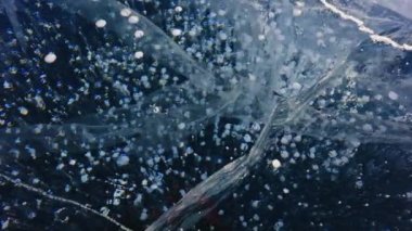 Bir sürü küçük beyaz baloncuk koyu mavi, berrak buzun içinde donmuş. Ayrıntılı görünüm.