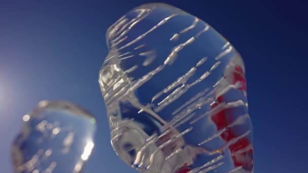 Esculturas de hielo luminosas. Figuras glaciales abstractas de pie sobre el cielo azul. — Vídeos de Stock