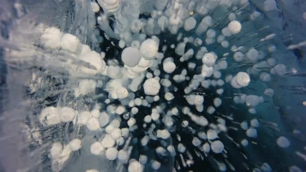 가까이 다가가면, 맑고 푸른 얼어붙은 얼음에 흰 둥근 거품 이 일어 납니다. 러시아, 바이칼호 — 비디오