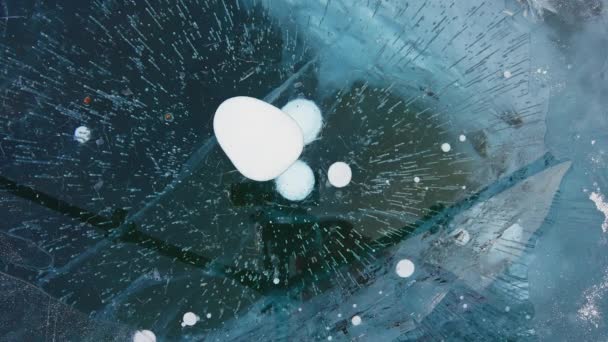 Large white bubbles freeze in deep dark blue clear ice. Frozen textures appears — Stock Video