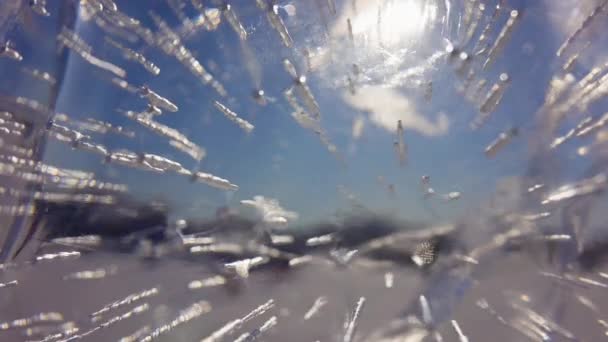 Вид сквозь прозрачный кристально толстый лед на солнце в голубом небе, солнечные лучи — стоковое видео