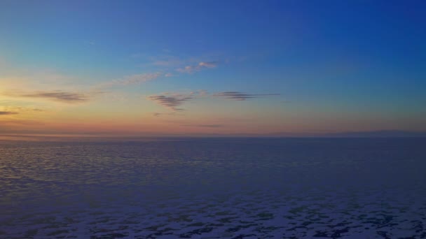 Vista aérea. Puesta de sol naranja sobre el horizonte. Crepúsculo sombrío sobre el lago helado. — Vídeos de Stock