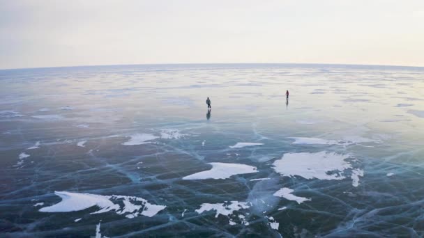 Panorama aereo. Pattinaggio al lago ghiacciato. Coppia planata all'orizzonte su ghiaccio liscio — Video Stock