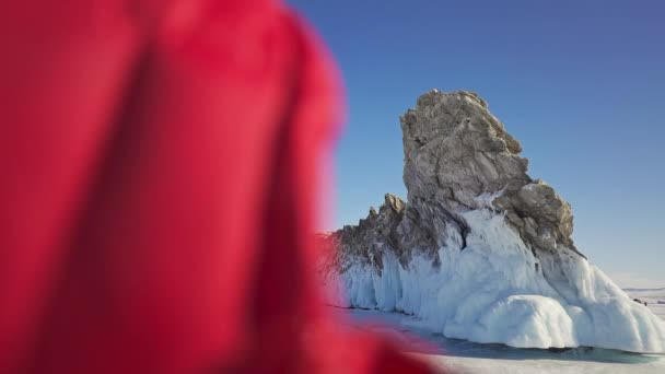 Powiększ, czerwony zakapturzony człowieku przed ostrym lodowatym klifem. Słońce błękitne niebo — Wideo stockowe