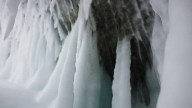 Donmuş buz saçakları, sarkıtlar mağarada tavanda asılı. Beyaz buz çivileri duvarı kaplıyor.