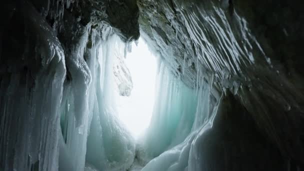 Zonlicht verlicht gladde bevroren muren in ijsgrot. — Stockvideo