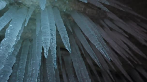 Longo afilamento branco icicles pendurar no teto dentro caverna de gelo, estalactites congelados — Vídeo de Stock