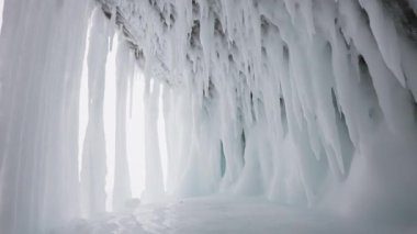 Mağaradaki beyaz donmuş buz sütunları. Sarkıtlar, sarkıtlar tavanda ve duvarlarda asılı.