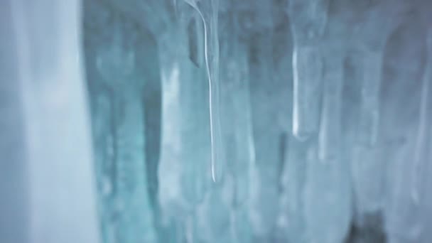 Los carámbanos blancos cristalinos lisos cuelgan dentro de la cueva de hielo. Formaciones de agua congelada — Vídeos de Stock