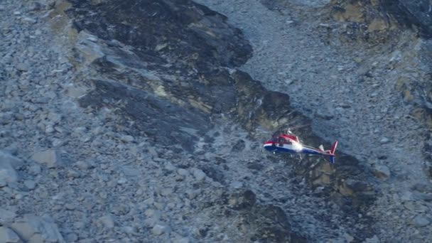 任務でヘリコプターを救助する。灰色の岩の山に沿って高く飛ぶチョッパー — ストック動画