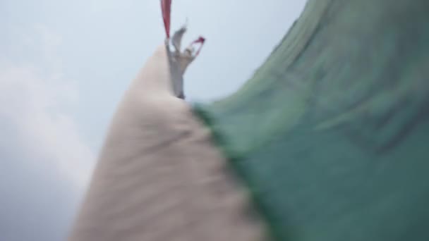 Вертикальні буддійські молитовні прапори, що ширяють на полюсі, священні літери, що ширяють у вітрі — стокове відео