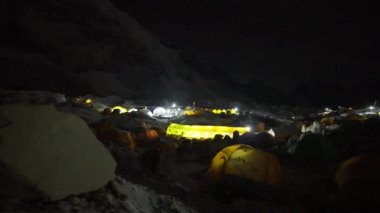 Sarı dağcılar karanlıkta Everest Ana Kampı 'nda ışıklarla aydınlatılmış çadırlardır.