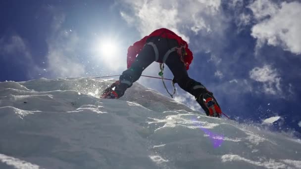 Equipped mountaineer climb over ice wall. Crystalline pieces falling from above — Stockvideo