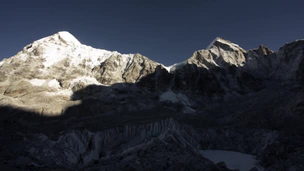 Gorgeous timelapse. Huge shadow move over mountains surface, reveal snowy summit — Vídeo de Stock