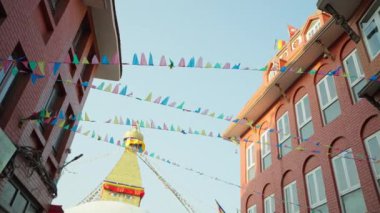 Swayambhunath yakınlarında mavi gökyüzünün altında çok renkli bayraklar dalgalanıyor.