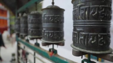 Bir dizi Budist dua davulları Kathmandu caddesinde dönüyor.