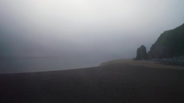 Panorama 'yı çember yapın. Terkedilmiş kumsalın üzerinde, sisli kayalık yeşil tepeler... Telifsiz Stok Video