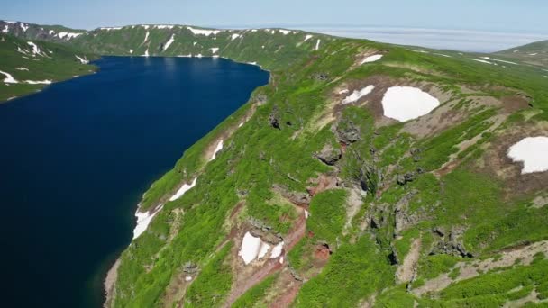 Letecké panorama. Let dronem podél zelených kopců podél pobřeží u modré vodní laguny — Stock video