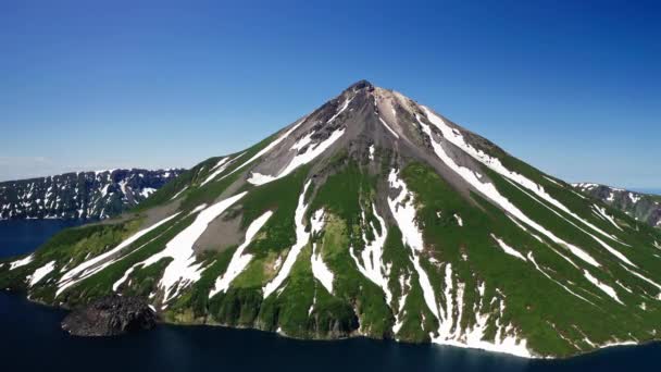 Glorioso panorama aéreo. Cono de volcán verde y blanco, agua azul alrededor, soleado — Vídeos de Stock