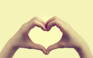 Kız el ile kalp şekli yapar