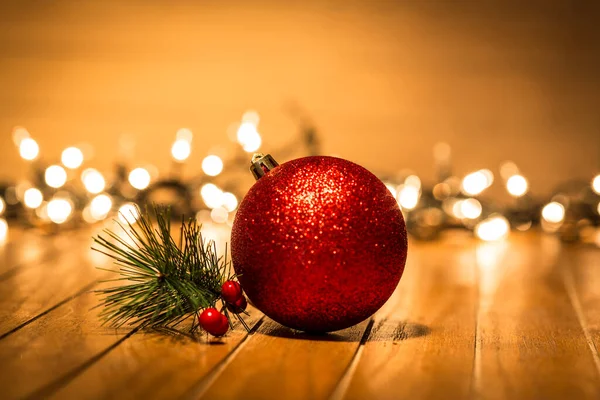 Schöne Rote Weihnachtskugel Auf Holzboden Mit Hintergrundbeleuchtung — Stockfoto