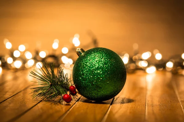 Schöne Grüne Weihnachtskugel Auf Holzboden Mit Hintergrundbeleuchtung — Stockfoto