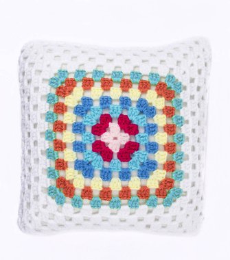 Beyaz arka planda el örgüsü, şirin bir yastık.