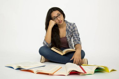 Genç ve mutlu Latin öğrenci beyaz arka planda okuyor..