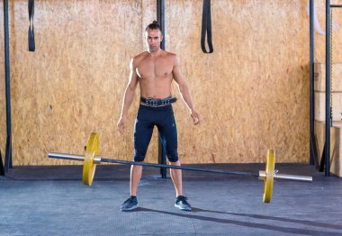 Genç ve atletik bir adam, spor salonunda egzersiz yapıyor.