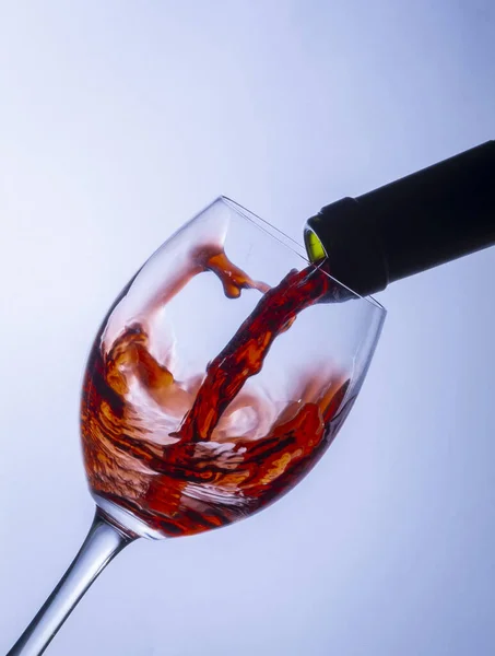 Serving a single glass of red wine from a bottle, splash
