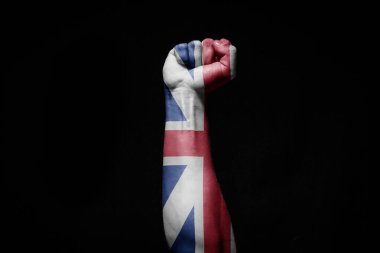 Siyah arka planda İngiltere bayrağı olan güçlü bir adamın eli savaş işareti.