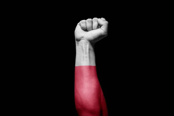 Strong man\'s hand in battle signal with Poland flag on black background.