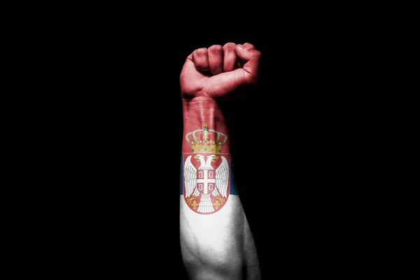 黒人を背景にセルビアの旗との戦闘信号で強い男の手 — ストック写真