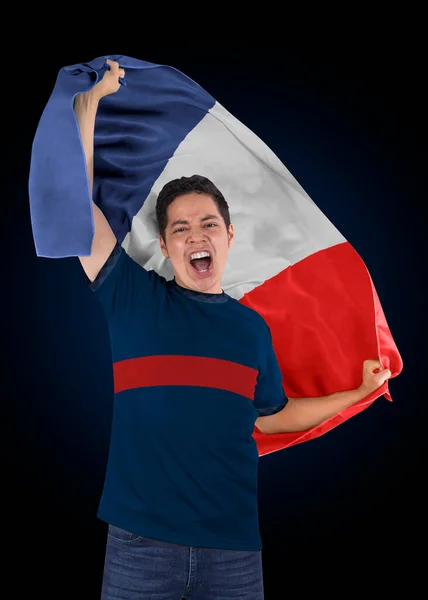 Soccer fan with the flag of his country France and jersey shouting with emotion for the victory of his team on a black background.