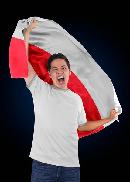 Soccer fan with the flag of his country Poland and jersey shouting with emotion for the victory of his team on a black background.