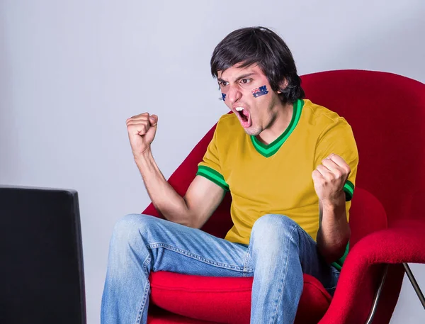 Ventilador Fútbol Viendo Televisión Con Camiseta Cara Pintada Con Bandera —  Fotos de Stock