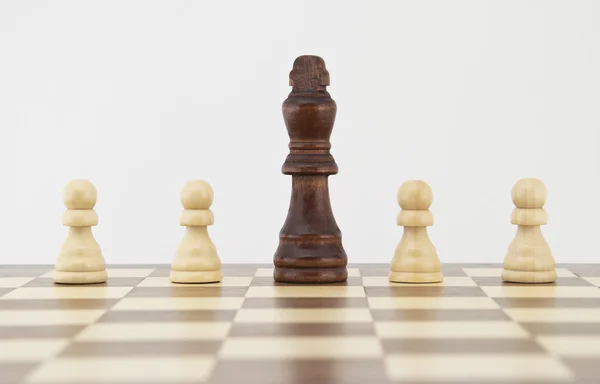 Chess king and pawns on chessboard — Stock Photo, Image