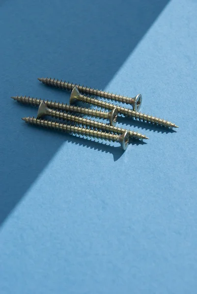 Chipboard Screws on light blue background — Stock Photo, Image