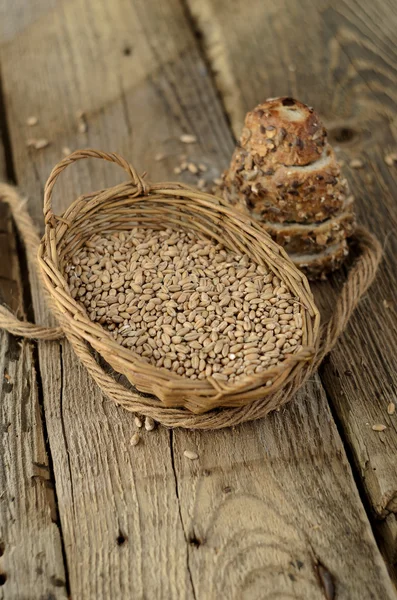 Sementes de trigo em uma cesta e fatias de pão — Fotografia de Stock