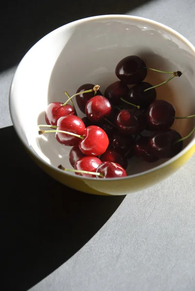 Red cherries in a white bowl — Stock Photo, Image