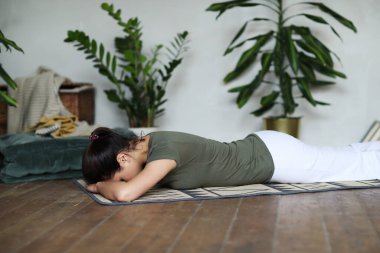 Evde yoga yapan bir kadın.